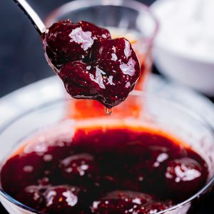 strawberry-jam-pouring-from-spoon-glassware-side-view